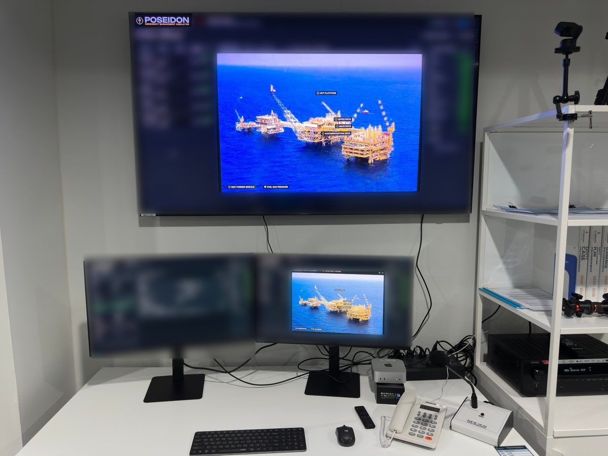 Poseidon Emergency Management Simulator workstation: wall display showing an offshore installation, with delegate screens and telephone.