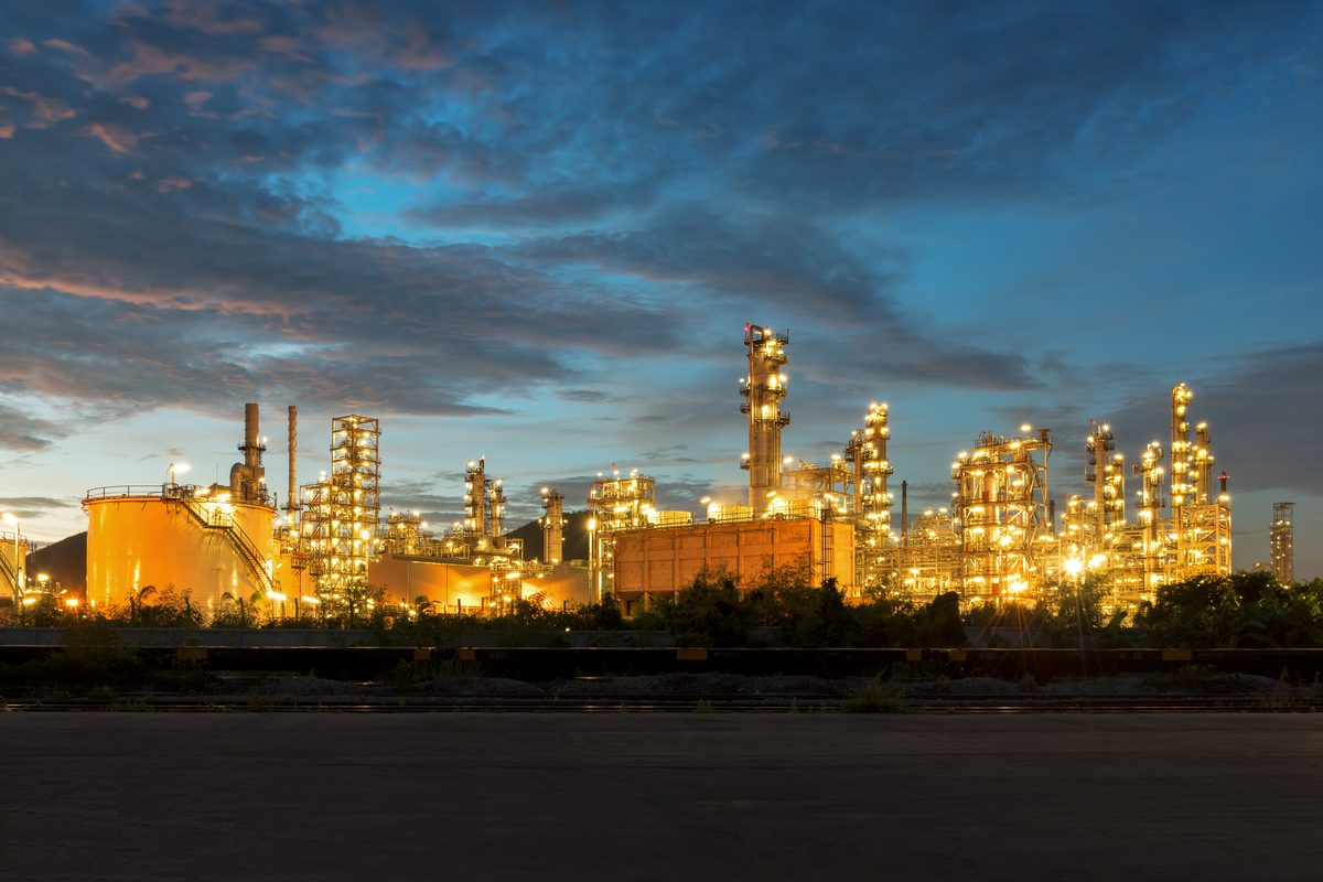 Onshore refinery lit at twilight.